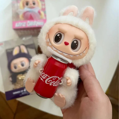 Toy figure holding a Coca-Cola can with a white hood, held by a hand.